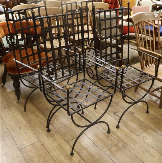A set of four wrought iron and brass dining chairs